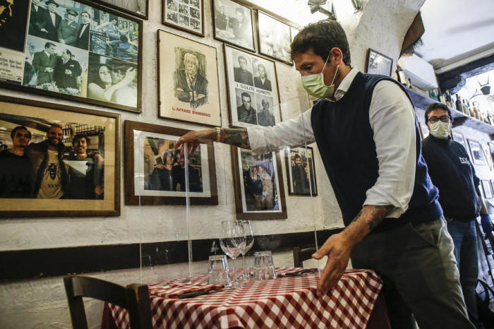 Giorgio Viscione von der Firma Nuova Gigaprint liefert einige Plexiglas-Separatoren für einen Test in einem typischen italienischen Restaurant ''Il Ciak'' im Trastevere Viertel in Rom. Foto: epa/Fabio Frustac