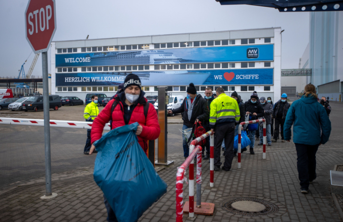 Mitarbeiter von externen Firmen verlassen das Gelände der MV Werft. Die Werften-Gruppe reichte beim Amtsgericht Schwerin den Insolvenzantrag ein. Foto: Jens Büttner/dpa