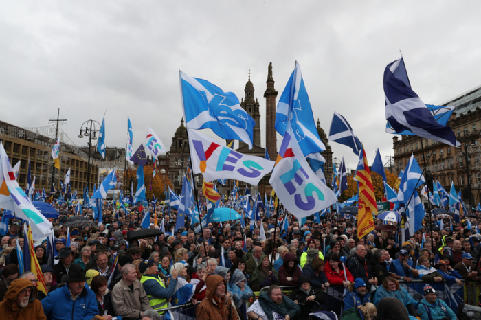 Teilnehmer einer Demonstration versammeln sich mit Fahnen zu einer Kundgebung. In Glasgow haben Tausende Schotten für eine Unabhängigkeit von Großbritannien demonstriert. Foto: Andrew Milligan/dpa