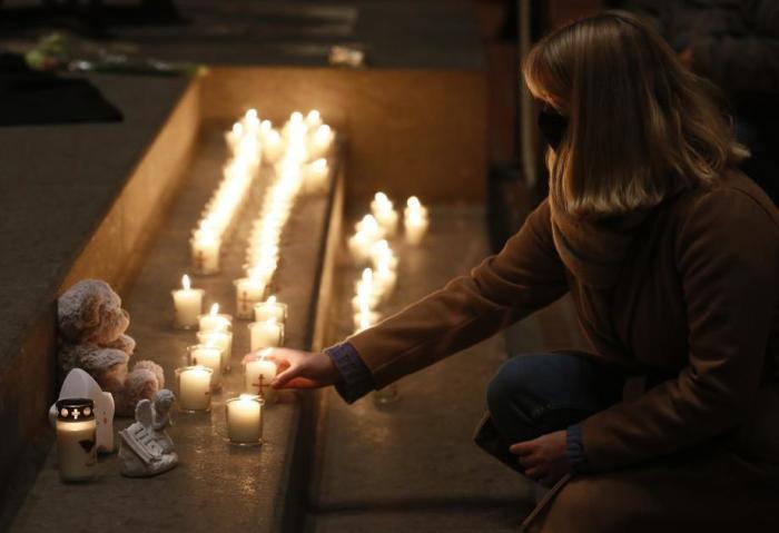 Im Trierer Petersdom zündet eine Frau während einer Messe für die Opfer im Petersdom eine Kerze an. Foto: epa/Julien Warnand
