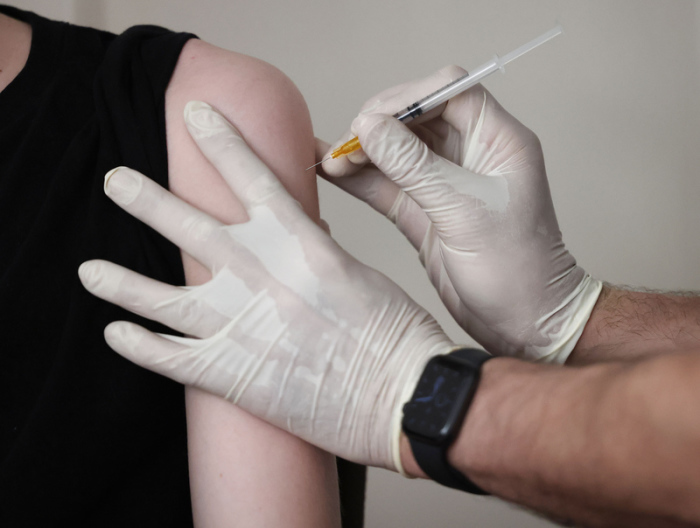 Der Hausarzt Tim Koop impft in seiner Praxis einen Jugendlichen mit dem Serum von Biontech/Pfizer. Foto: Oliver Berg/dpa
