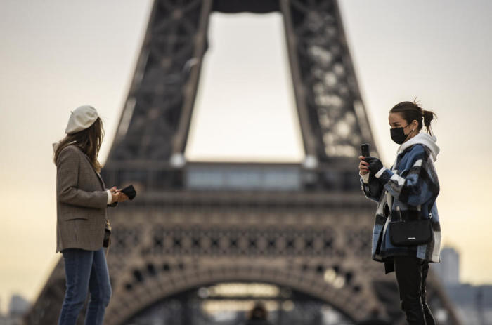 Fussgänger tragen Schutzmasken in der Nähe des Eiffelturms in Paris. Foto: epa/Ian Langsdon