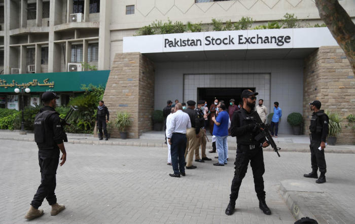 Pakistanische Sicherheitsbeamte stehen vor dem Gebäude der Pakistanischen Börse (PSX) Wache, nachdem sie nach einem Terroranschlag in Karatschi geräumt und die Handelssitzung wieder aufgenommen wurden. Foto: epa/Rehan Khan