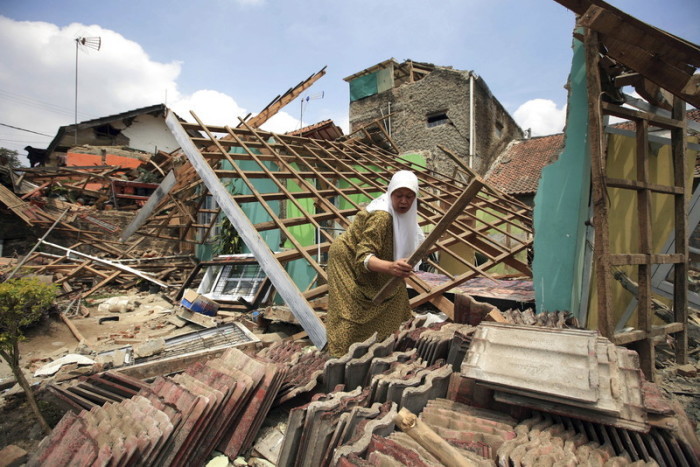Eine indonesische Frau versucht, ihr beschädigtes Haus nach einem Erdbeben in Java zu reparieren. Foto: epa/Adi Weda