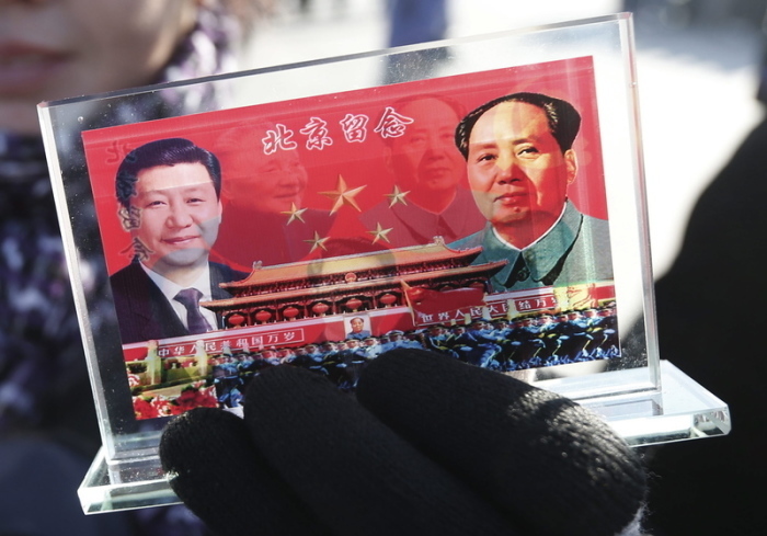 Ein Verkäufer bietet ein Souvenir mit den Konterfeis des chinesischen Staats- und Parteichefs Xi Jinping (l) und des 