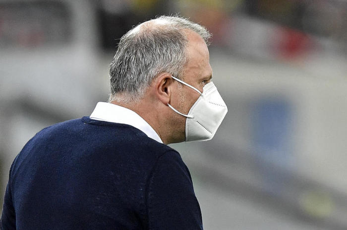 Schalke-Sportdirektor Jochen Schneider mit einer Gesichtsmaske auf dem Spielfeld. Foto: epa/Martin Meissner