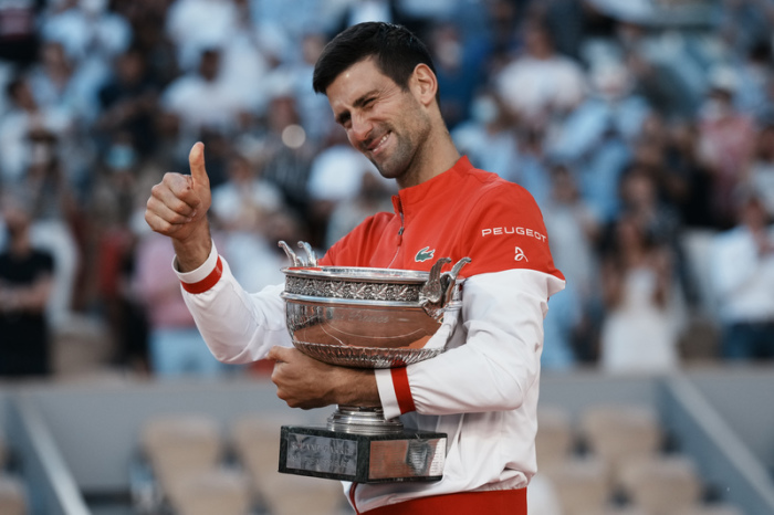 Novak Djokovic hält die Trophäe und zeigt einen Daumen nach oben. Foto: Thibault Camus/Ap/dpa
