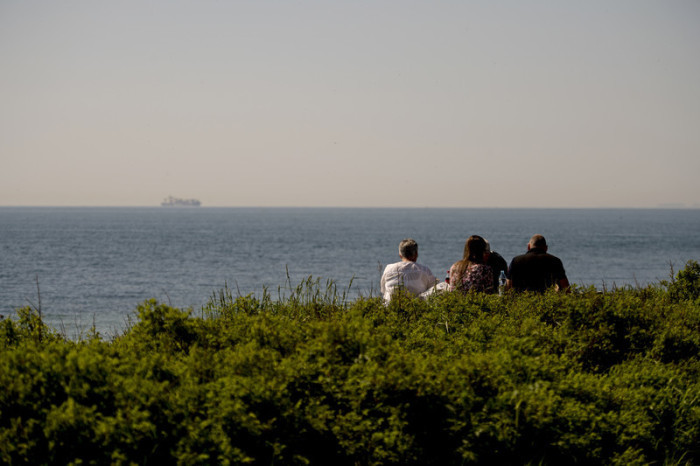 Leute rasten an der Küste der dänischen Insel Seeland bei Halsskov. Foto: epa/Christian Bruna