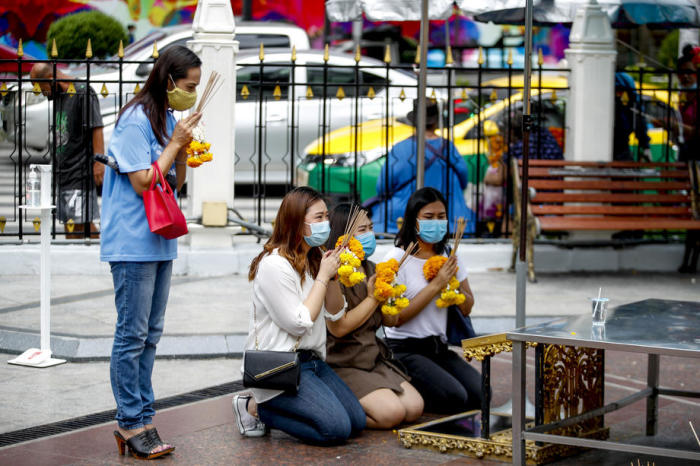 Am Erawan-Schrein in Bangkok tragen Besucher Nasen-Mund-Schutzmasken beim Gebet, um Lord Brahma zu verehren. Foto: epa/Diego Azubel