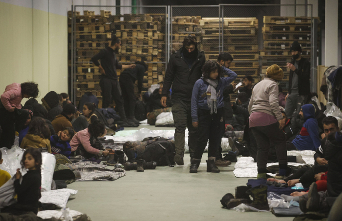 Migranten richten sich im Logistikzentrum am Kontrollpunkt «Kuznica» für die Nacht ein. Ein erster Sonderflug mit irakischen Migranten an Bord ist am Donnerstag in Belarus gestartet. Foto: Leonid Shcheglov/Belta/ap/dpa