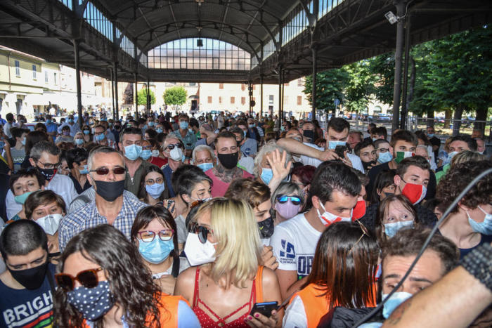 Menschen, meist mit Gesichtsmasken, warten in Codogno, Norditalien. Foto: epa/Matteo Corner
