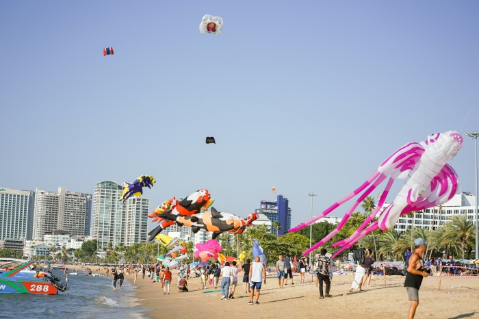 Bunte Drachen schweben über dem Strand von Pattaya und ziehen zahlreiche Besucher an. Foto: Central Pattaya