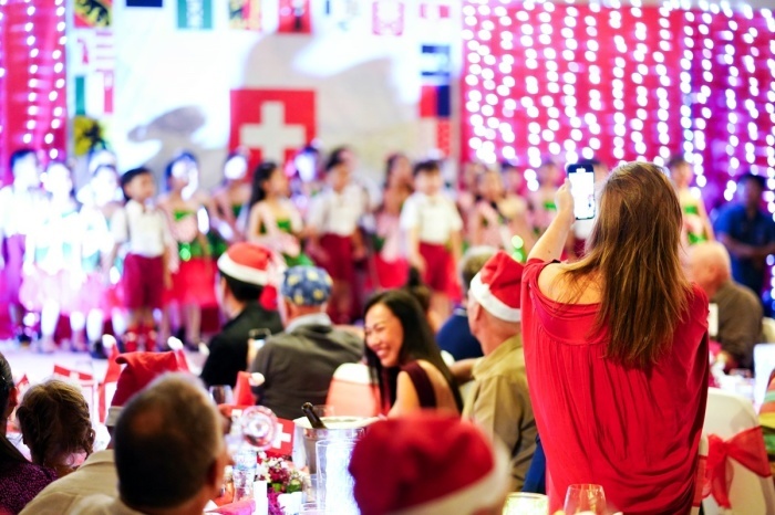 Gäste halten mit dem Smartphone den Auftritt des Kinderchors bei der SSP-Weihnachtsfeier im Amari Patong fest. Bilder Swiss Society Phuket (SSP)