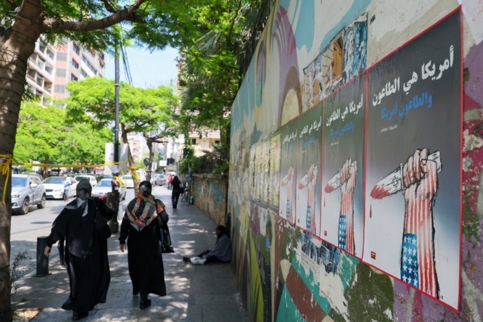 Frauen gehen in Beirut an politischen Plakaten vorbei, die sich gegen die USA und Israel richten. Foto: epa/Wael Hamzeh