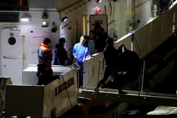 In Bari steigen Migranten auf dem Rückweg von Albanien aus einem Patrouillenboot aus. Foto: epa/Donato Fasano
