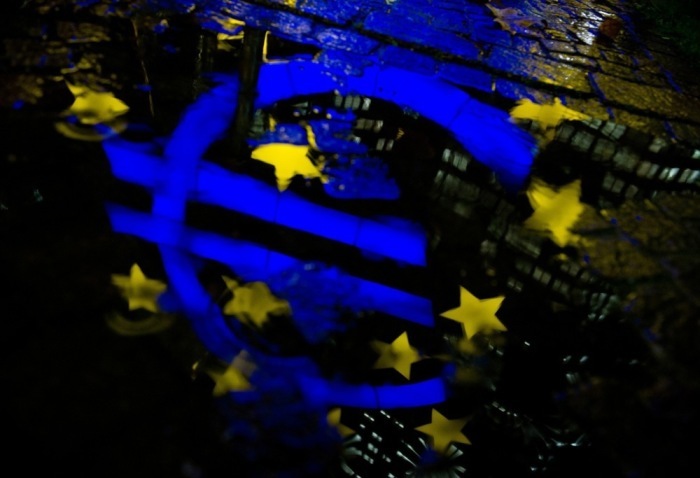 Das Euro-Logo spiegelt sich in einer Pfütze vor dem Gebäude der Europäischen Zentralbank (EZB) in Frankfurt am Main. Foto: epa/Boris Roessler