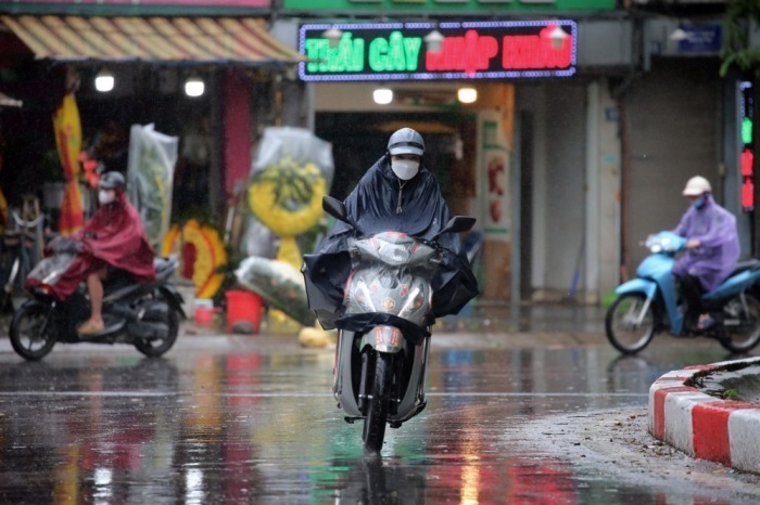 Motorradfahrer trotzen dem Regen in Hanoi, wo Taifun Wipha am 22. Juli auf Land treffen soll. Foto: epa/Luong Thai Linh