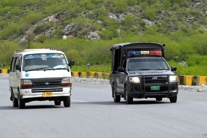 Unter Polizeibegleitung fahren Fahrzeuge mit afghanischen Migranten über die Bergstraße nahe Torkham zur Grenze, wo Pakistan die Rückführung organisiert. Foto: EPA/Bilawal Arbab