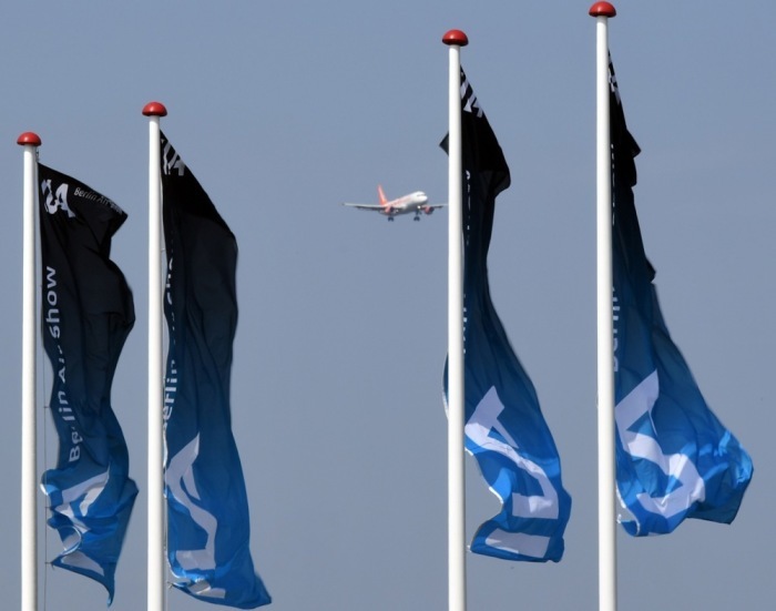 Bei der Landung eines Flugzeugs auf dem Flughafen Schönefeld wehen Fahnen mit dem ILA-Logo im Wind. Archivfoto: epa/RALF HIRSCHBERGER