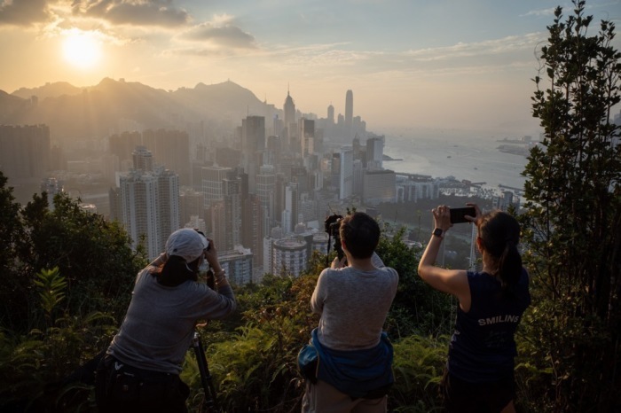 Fotografiebegeisterte fotografieren die untergehende Sonne über der Insel Hongkong in Hongkong. Foto: epa/Jerome Favre