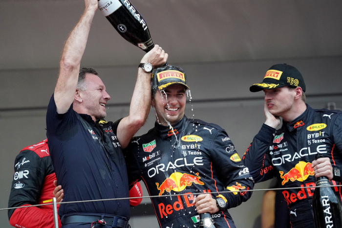 Red-Bull-Pilot Sergio Perez aus Mexiko (M) feiert seinen Sieg mit Teamchef Christian Horner von Red Bull Racing (l) und Red-Bull-Pilot Max Verstappen aus den Niederlanden (r) auf dem Podium. Foto: Hasan Bratic/dpa