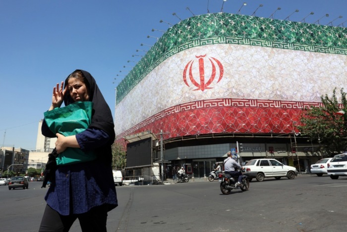Iraner gehen an einer Flaggen-Werbetafel in Teheran vorbei, nachdem US-Präsident Trump ein baldiges Abkommen in Aussicht gestellt hat. Foto: epa/Abedin Taherkenareh
