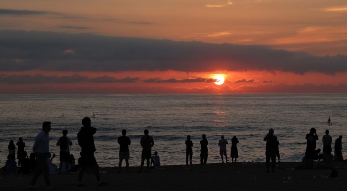Touristen beobachten am Strand von Gangneung den Sonnenaufgang, der zahlreiche Besucher früh anlockt an der Ostküste Südkoreas zudem. Foto: EPA/Yonhap