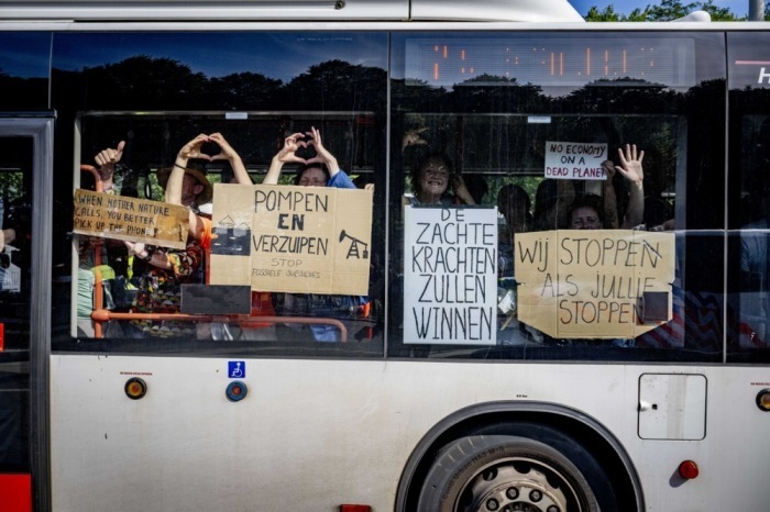 Klimaschützer demonstrieren in einem Bus auf der A12 in Den Haag. Foto: epa/Robin Utrecht