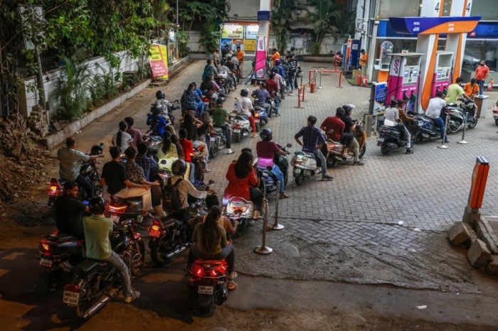 Motorradfahrer warten an einer Tankstelle in Mumbai, nachdem Premier Modi zum Sparen von Kraftstoff aufgerufen hat. Foto: EPA/Divyakant Solanki