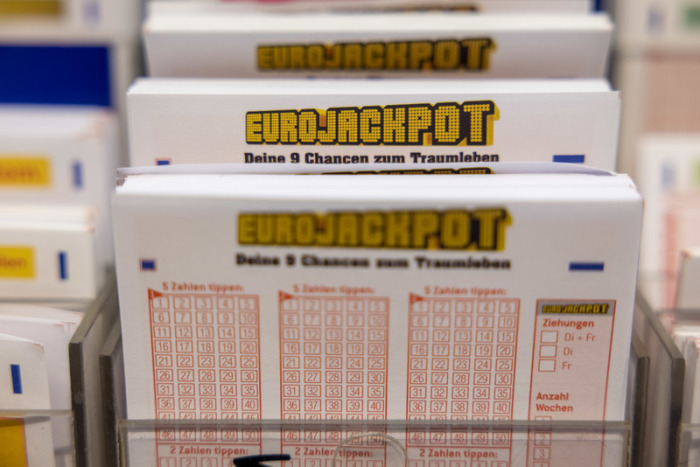 Eurojackpot-Spielscheine stehen in einem Regal in einer Lotto-Annahmestelle. Foto: Thomas Banneyer/dpa