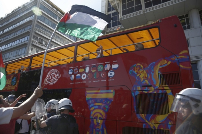 Ein Tourist in einem Bus reagiert auf Demonstranten im Hafen von Piräus, die gegen die Ankunft eines Kreuzfahrtschiffs protestieren. Foto: epa/Yannis Kolesidis