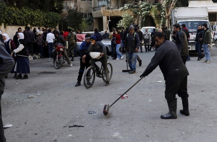 Ein Müllwerker entfernt Trümmer vom Ort eines Raketeneinschlags in Damaskus. Foto: epa/Youssef Badawi