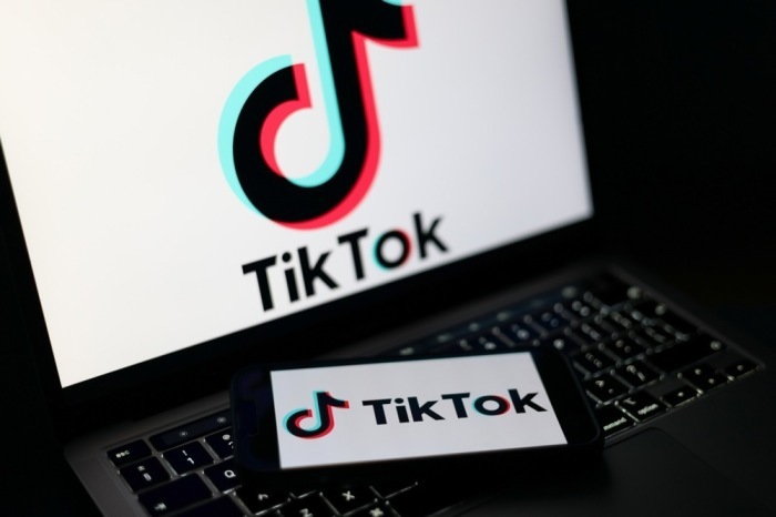Das Logo der TikTok-Plattform auf einem Smartphone und Laptop. In Großbritannien wird ein mögliches Social-Media-Verbot für unter 16-Jährige diskutiert. Foto: EPA/Adam Vaughan
