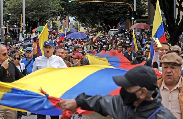 Menschen tragen eine riesige Nationalflagge, während sie an einem Marsch gegen die Politik der Regierung von Präsident Gustavo Petro in Bogotá teilnehmen. EPA-EFE/MAURICIO DUENAS CASTANEDA