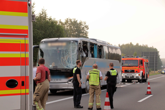 Rettungskräfte stehen neben einem beschädigten Reisebus auf der Autobahn 24. Der Bus aus Polen mit 59 Menschen an Bord war zwischen Hamburg und Berlin nach ersten Erkenntnissen von der Fahrbahn abgekommen. Foto: SWM DV Studio Ralf Drefin/dpa