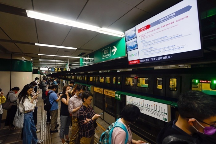 In einer U-Bahn-Station in Taipeh warten die Fahrgäste unter einem Bildschirm, auf dem eine Durchsage über den Ausfall eines U-Bahn-Zuges nach einem Erdbeben der Stärke 7,4 in der Nähe von Hualien angezeigt wird. Foto: epa/Daniel Ceng