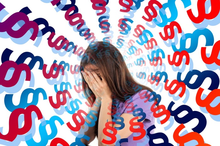 Umgeben von verwirrenden Paragraphenzeichen kämpft eine Person gegen die Überlastung – ein Bild des modernen Stress. Foto: Pixabay/Gerd Altmann