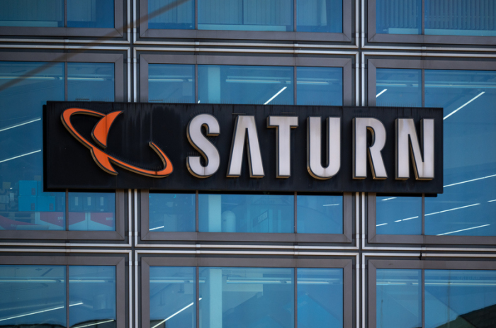 Ein Schild mit dem Saturn-Logo ist an der Hausfassade des Elektronikmarktes am Berliner Alexanderplatz angebracht. Foto: Monika Skolimowska/dpa