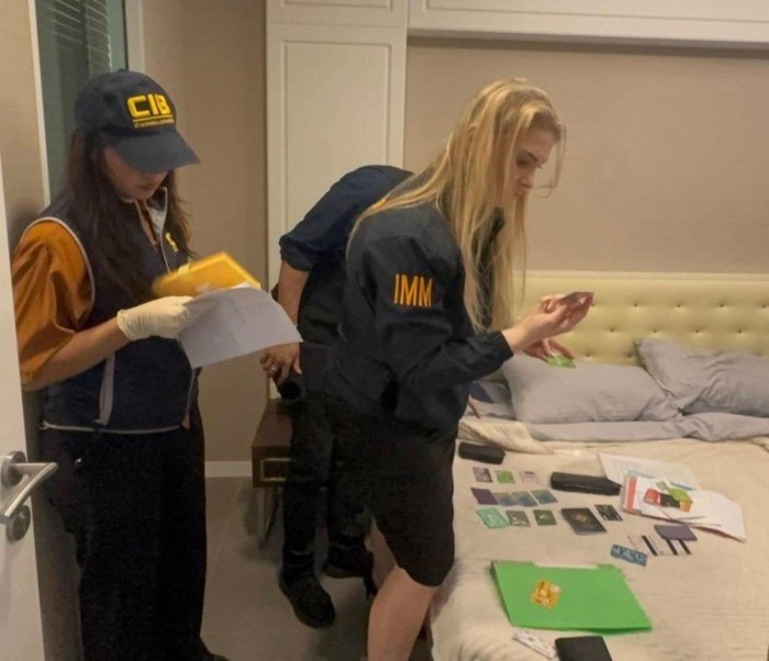 Ermittler des CIB sichern bei einer Durchsuchung in einem Condominium mehrere Karten und elektronische Geräte als Beweismittel. Bild: Central Investigation Bureau (CIB)