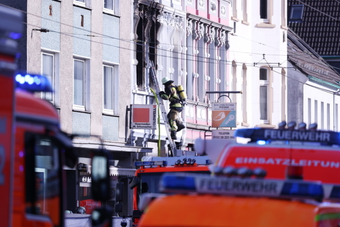 Ein Feuerwehrmann klettert an einem Haus, in dem es gebrannt hat, auf einer Leiter. Bei dem Wohnungsbrand am frühen Montagmorgen sind drei Menschen getötet worden, darunter ein Kind. Foto: David Young/dpa