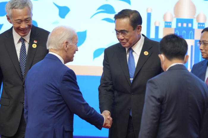 Joe Biden (M, l), Präsident der USA, gibt Prayuth Chan-O-Cha (M, r), Ministerpräsident von Thailand, während des ASEAN Gipfels die Hand. Biden nimmt als besonderer Gast am Gipfeltreffen des Verbands südostasiatischer... Foto: Vincent Thian/Ap/dpa
