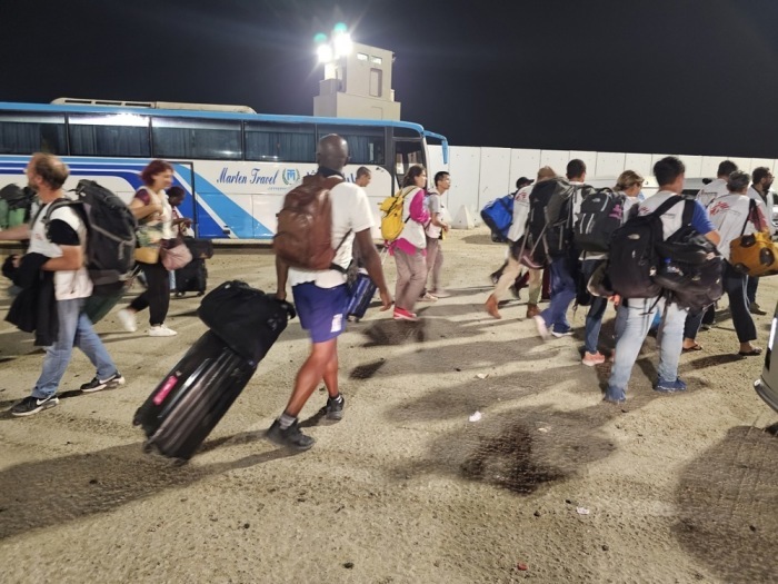 Einige ausländische Staatsangehörige gehen nach dem Passieren des Grenzübergangs Rafah zwischen dem Gazastreifen und Ägypten zu Fuß. Foto: epa/Stringer