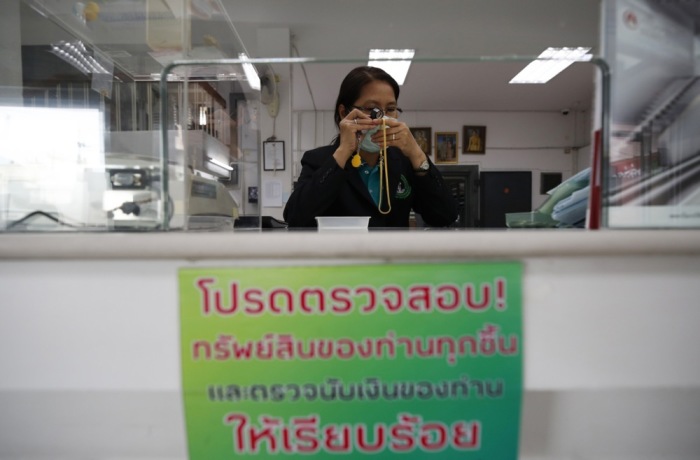 Eine thailändische Pfandleiherin begutachtet eine von einem Kunden verpfändete Goldkette in einem von der Stadtverwaltung Bangkok betriebenen Pfandhaus. Archivbild: epa-efe/Rungroj Yongrit
