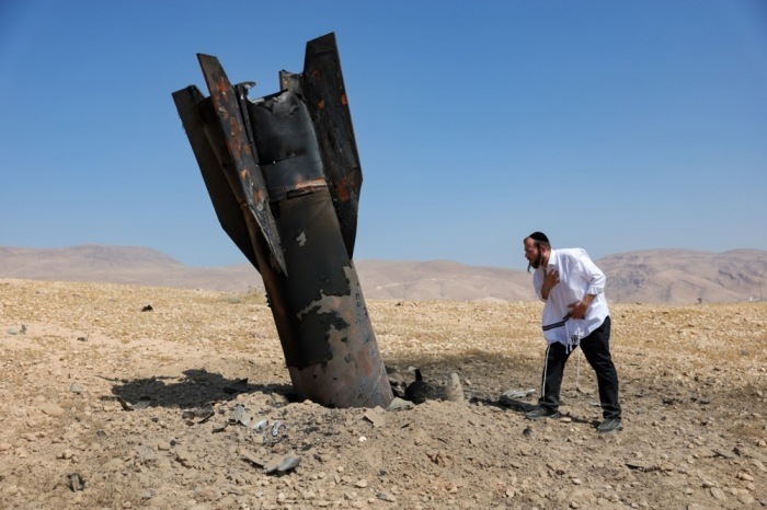Ein ultraorthodoxer Jude betrachtet die Überreste einer iranischen ballistischen Rakete nahe der Siedlung Mevo’ot Yericho im Jordantal. Foto: epa/Abir Sultan