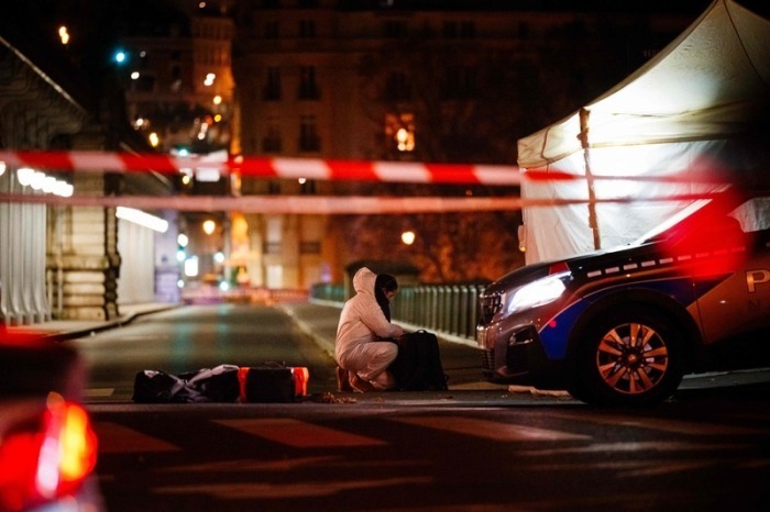 Ein Beamter der Kriminalpolizei arbeitet am Tatort. Ein mutmaßlicher Islamist hat unweit des Eiffelturms am Samstagabend einen deutschen Touristen mit einem Messer getötet. Foto: Dimitar Dilkoff/Afp/dpa