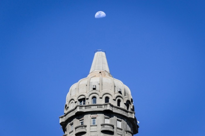 Der Mond steht über dem Palacio Salvo in Montevideo und prägt das nächtliche Stadtbild. Foto: Raul Martinez/epa