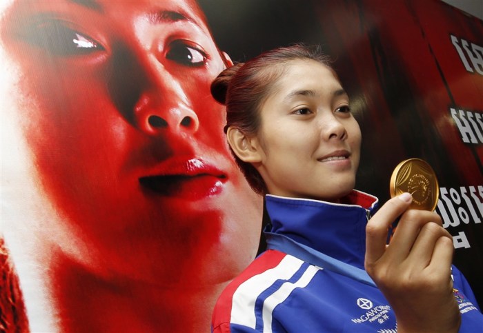 Die Kambodschanerin Sorn Seavmey zeigt ihre Goldmedaille, welche sie im Taekwondo-Finale 2014 der Frauen bei den 17. Asienspielen in Incheon, Südkorea gewann. Foto: EPA/Mak Remissa