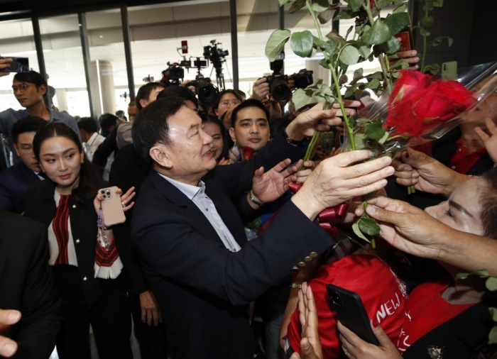 Thaksin Shinawatra, umgeben von Anhängern, bei seinem ersten Besuch im Pheu Thai Hauptquartier nach seiner teilweisen Begnadigung. Foto: EPA-EFE/Rungroj Yongrit