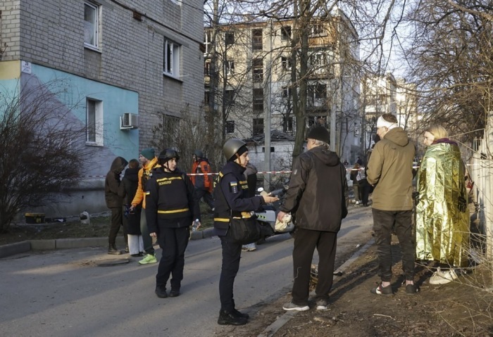 Militärpsychologe spricht mit Anwohnern am Ort des Beschusses von Wohnhäusern in Charkiw. Foto: epa/Sergey Kozlov