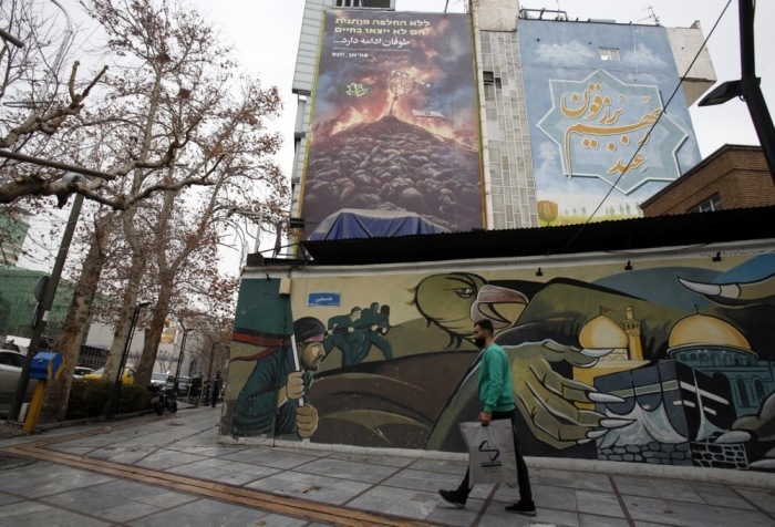 Ein Mann aus dem Iran geht an einem Wandgemälde in der Nähe eines Gebäudes vorbei. Foto: epa/Abedin Taherkenareh
